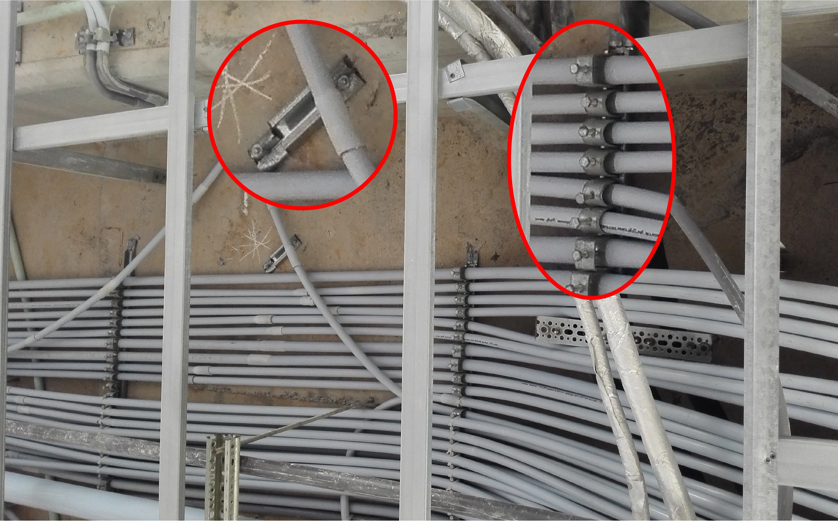 Rail and claw clamps used to support electrical conduit.